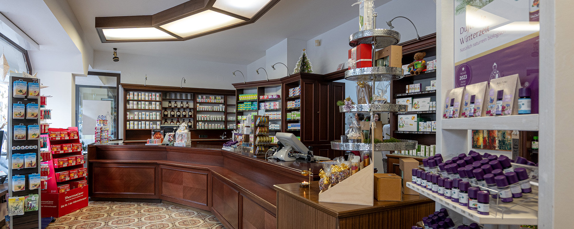 Innenraum einer Apotheke mit Verkaufstresen, Regalen voller Produkte und einem einladenden, gut strukturierten Layout.